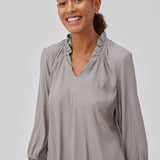 Top in grey with a relaxed fit. GilliganMD top has a v-shaped neckline with ruching around the neck and 3/4 length balloon sleeves with elastics at cuff. The model is 175 cm and wears a size S/36.