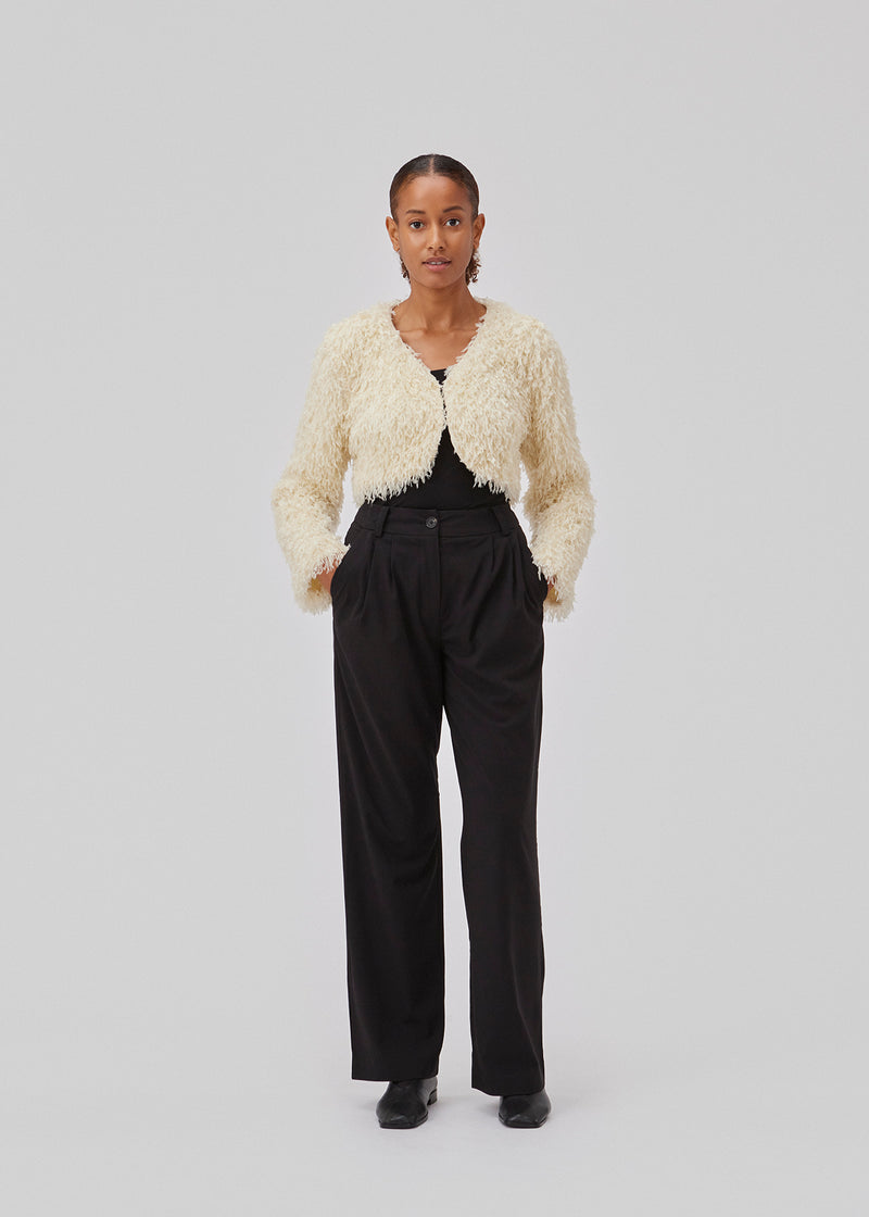 Cropped, light jacket in white in a feather-like quality. GinaMD jacket has long sleeves, v-neckline and hook and clasp closure in front. Rounded hems at the bottom. The model is 175 cm and wears a size S/36.