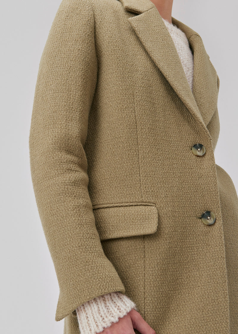 Single-breasted blazer made from a structured quality with wool. GinniMD jacket is designed with an oversized fit with collar and lapel, front pockets with flaps and a vent in back. Lined. The model is 175 cm and wears a size S/36.