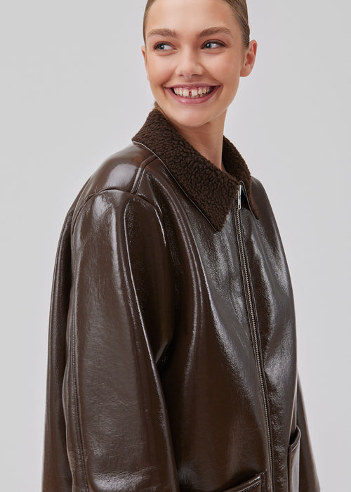 Coat in faux leather with a shiny finish in a slightly oversized fit. GioMD coat has large patch pockets in front, a chunky zipper and teddy detailing on the collar. The model is 175 cm and wears a size S/36.