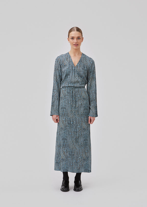 Printed dress in mid length. GladstoneMD print dress has a wrap effect with a narrow tie belt at the waist, and a v-shaped neckline. Long sleeves with slit. The model is 175 cm and wears a size S/36.