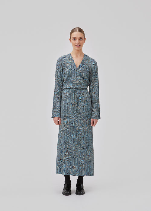 Printed dress in mid length. GladstoneMD print dress has a wrap effect with a narrow tie belt at the waist, and a v-shaped neckline. Long sleeves with slit. The model is 175 cm and wears a size S/36.