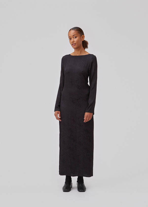 Long sleeved dress in jacquard satin. GraceyMD dress is designed with a relaxed fit and a deep opening in the back with lacing and narrow ties. Slit at center back. The model is 175 cm and wears a size S/36.