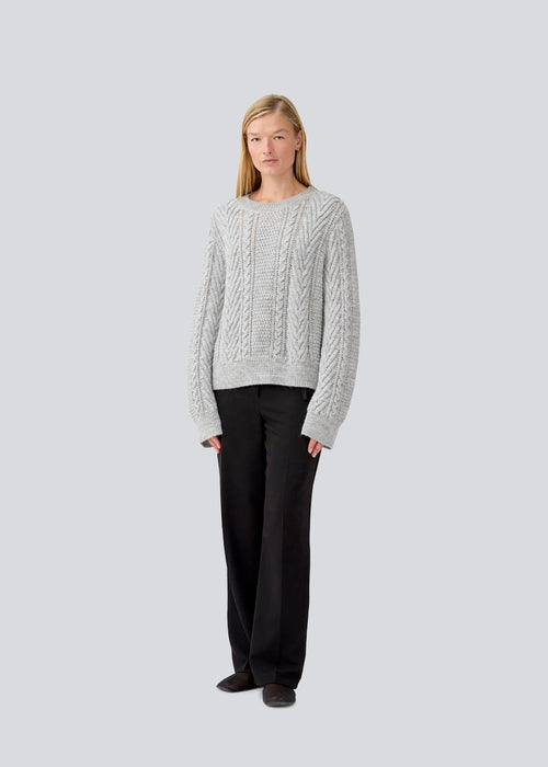 Grey cableknit jumper in wool-blend quality. GrannonMD o-neck has a relaxed fit with long sleeves and a round neck, with rib trimmings at neck, sleeves and hem. The model is 175 cm and wears a size S/36.