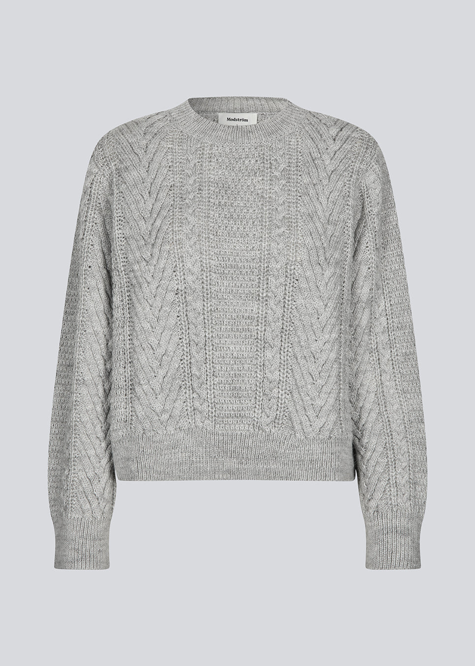 Grey cableknit jumper in wool-blend quality. GrannonMD o-neck has a relaxed fit with long sleeves and a round neck, with rib trimmings at neck, sleeves and hem. The model is 175 cm and wears a size S/36.