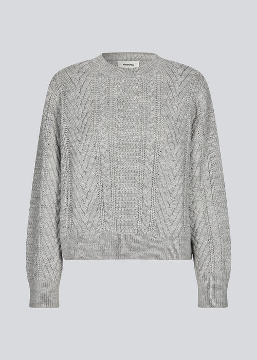 Grey cableknit jumper in wool-blend quality. GrannonMD o-neck has a relaxed fit with long sleeves and a round neck, with rib trimmings at neck, sleeves and hem. The model is 175 cm and wears a size S/36.