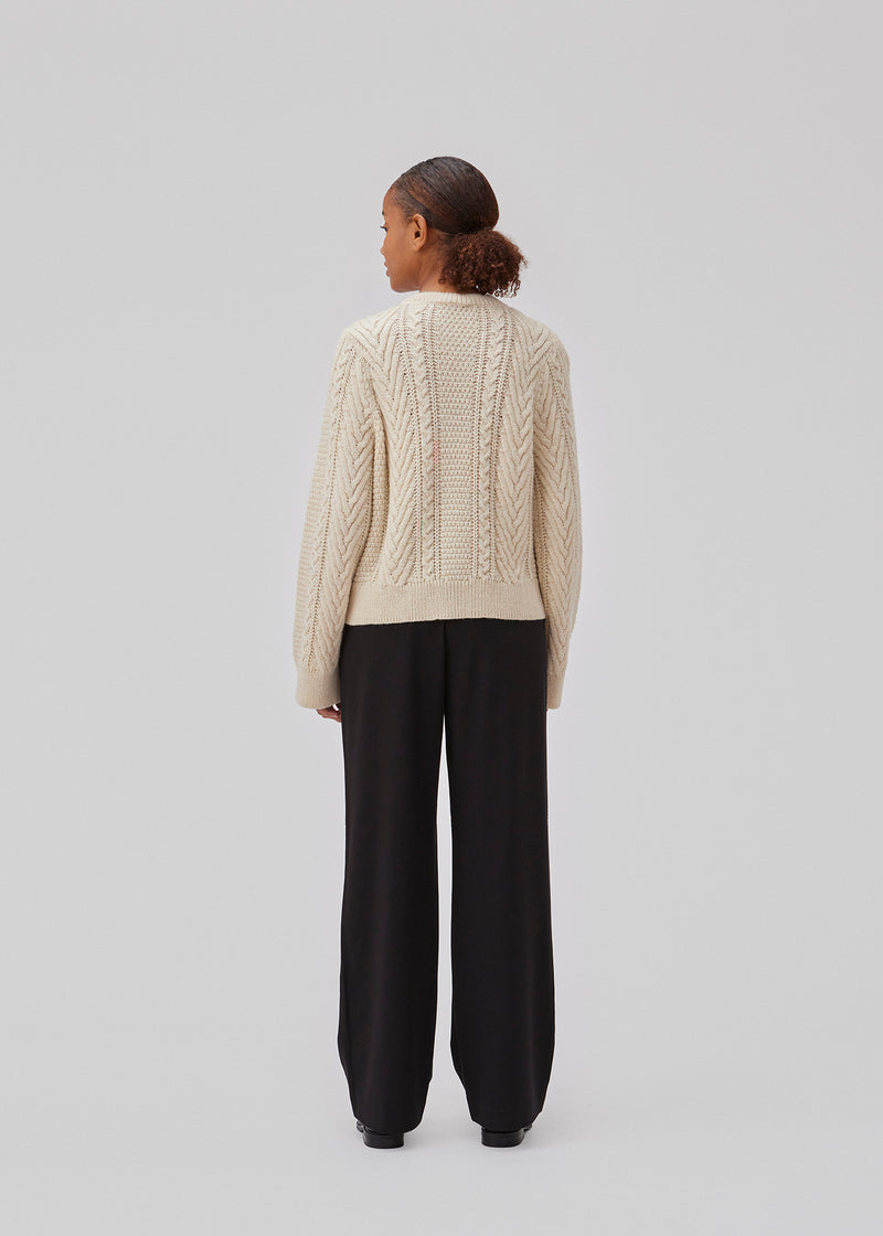 Cableknit jumper in white in wool-blend quality. GrannonMD o-neck has a relaxed fit with long sleeves and a round neck, with rib trimmings at neck, sleeves and hem. The model is 175 cm and wears a size S/36.