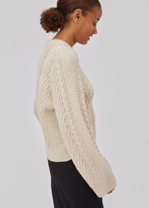 Cableknit jumper in white in wool-blend quality. GrannonMD o-neck has a relaxed fit with long sleeves and a round neck, with rib trimmings at neck, sleeves and hem. The model is 175 cm and wears a size S/36.