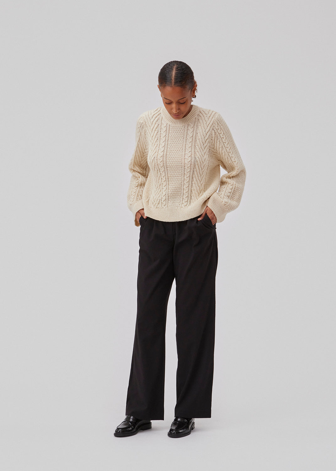 Cableknit jumper in white in wool-blend quality. GrannonMD o-neck has a relaxed fit with long sleeves and a round neck, with rib trimmings at neck, sleeves and hem. The model is 175 cm and wears a size S/36.