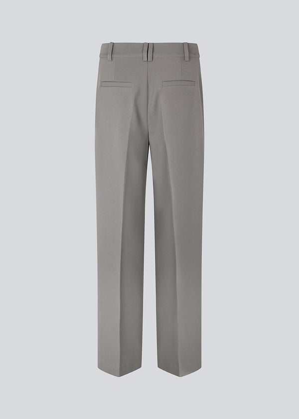 Tailored pants with wide, straight legs with creases in front and back. GrayMD pants have a high waist with a zip fly and fabric-covered button. Lined. The model is 175 cm and wears a size S/36.