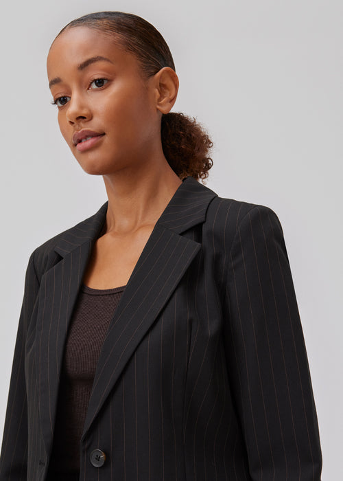 Tailored blazer in a woven quality with a slight stretch. GraysonMD blazer is single-breasted with very rounded hems in front, with a slightly longer back and no back vent. Slits on the sleeves. The model is 175 cm and wears a size S/36.