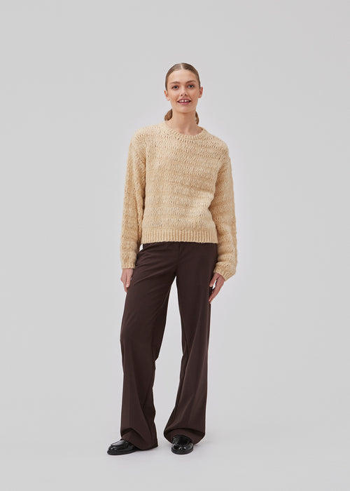 Woolen jumper in beige with long stitches for a relaxed look. GroverMD o-neck has long sleeves with volume, a round neck with ribbed details. Contains wool and alpaca. The model is 175 cm and wears a size S/36.