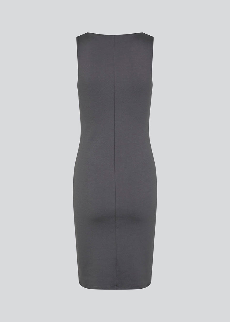 Figure-hugging dress in grey with a high boat neck. HakanMD dress is sleeveless, and a midi length cutting at the knees. The model is 175 cm and wears a size S/36.<br>
