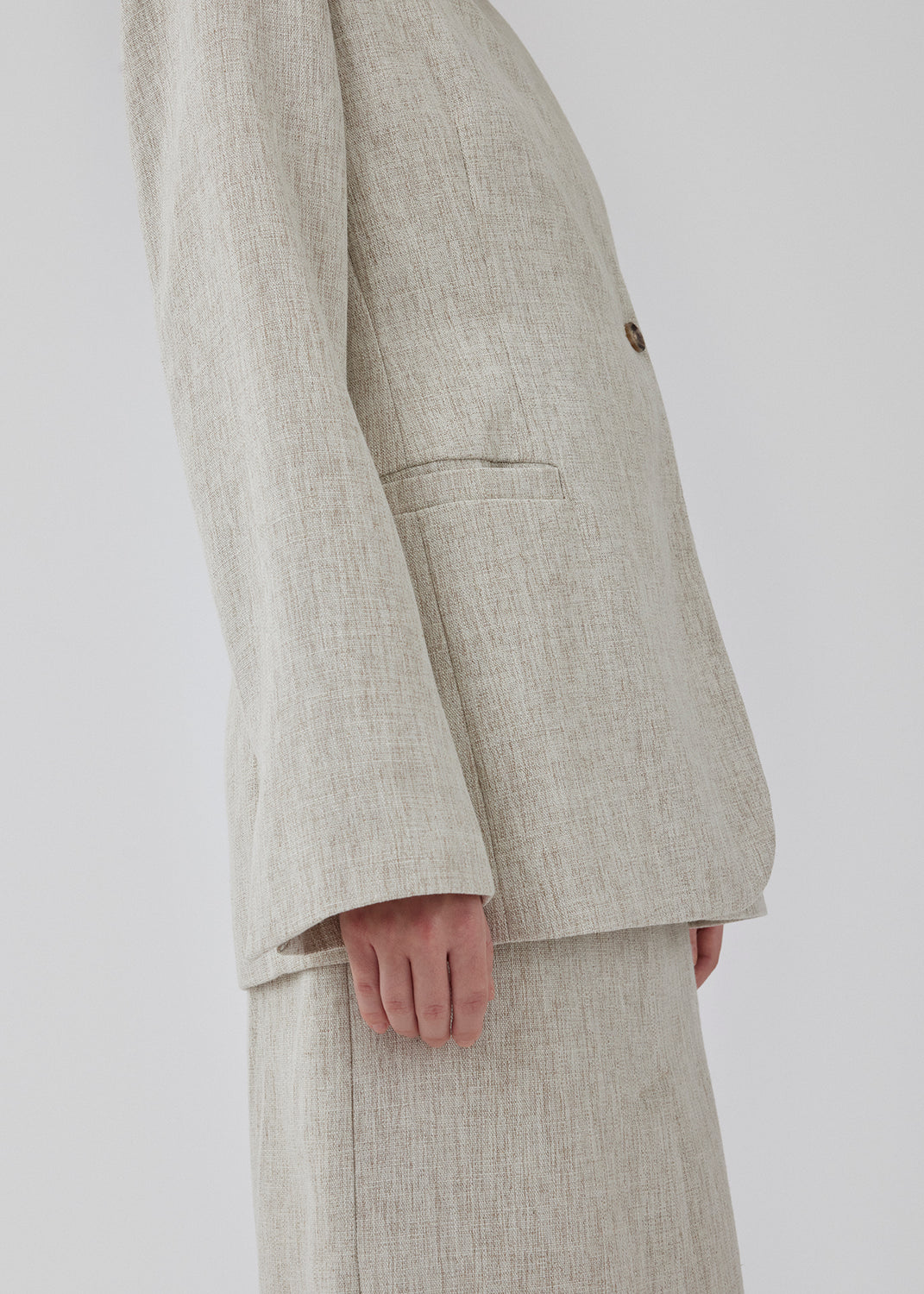 Blazer with a slightly oversized shape and an asymmetrical button closure in front. HaleyMD blazer is collarless, with two welt pockets in front, and a slit in the back. The model is 175 cm and wears a size S/36.