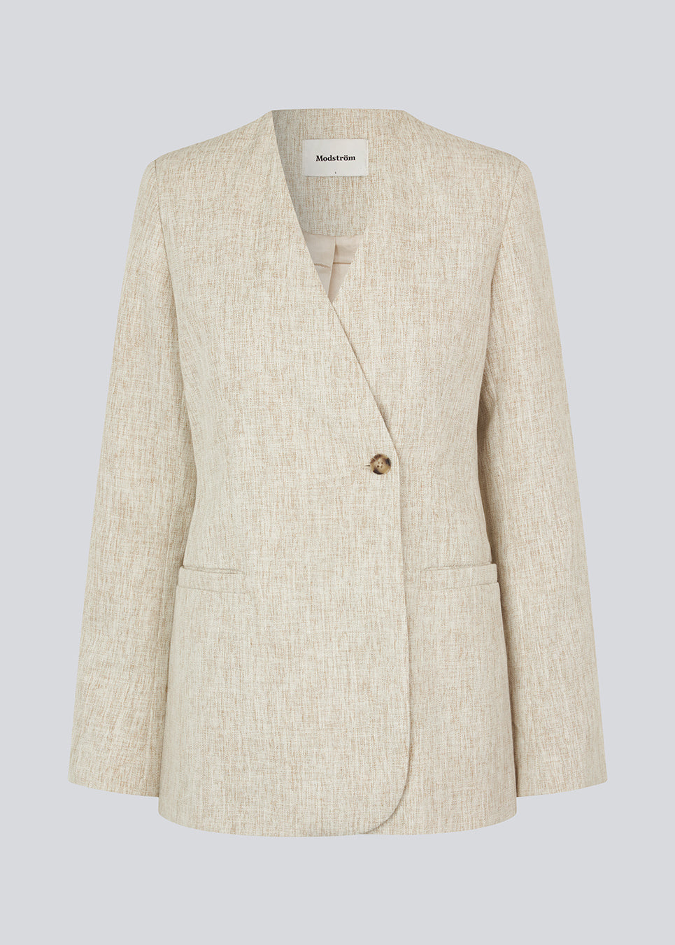 Blazer with a slightly oversized shape and an asymmetrical button closure in front. HaleyMD blazer is collarless, with two welt pockets in front, and a slit in the back. The model is 175 cm and wears a size S/36.