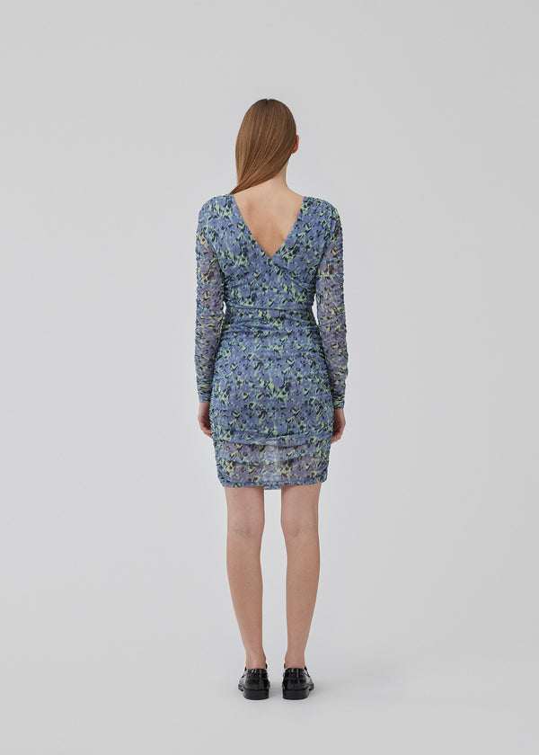 Short dress with a figure-hugging, stretchy fit. HamiltonMD print dress has a v-neckline at the back, long transparent sleeves, and elastic ruching at sides and on the sleeves. The model is 175 cm and wears a size S/36.