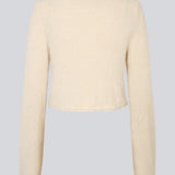 Cropped cardigan in beige made from a fluffy material. HamptonMD cardigan has long sleeves, v-shaped neckline, and is closed with two buttons in front. The model is 175 cm and wears a size S/36.
