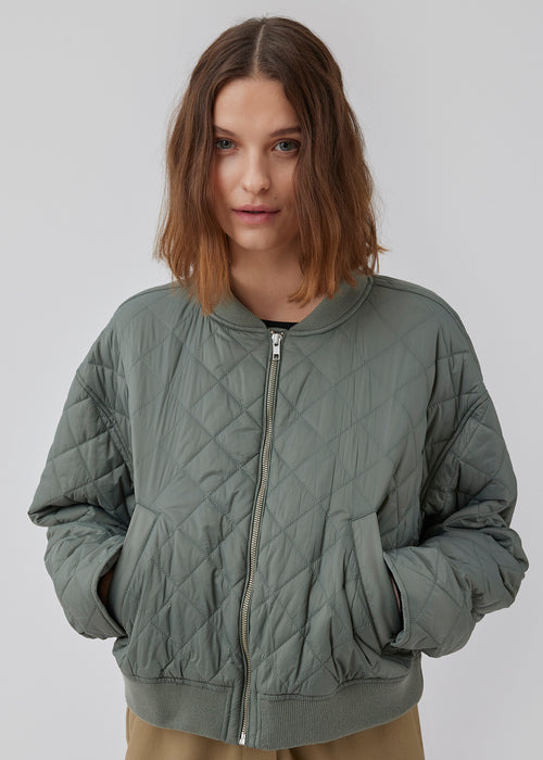 Lightly padded jacket in a quilted material with a short, ribbed collar, and zipper in front. HankMD jacket has a short and loose fit. Made from recycled nylon. The model is 175 cm and wears a size S/36.
