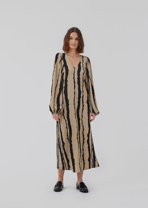 Printed midi dress with a v-neckline and long balloon sleeves with elastic. HarlandMD print dress has a loose silhouette. The model is 175 cm and wears a size S/36.