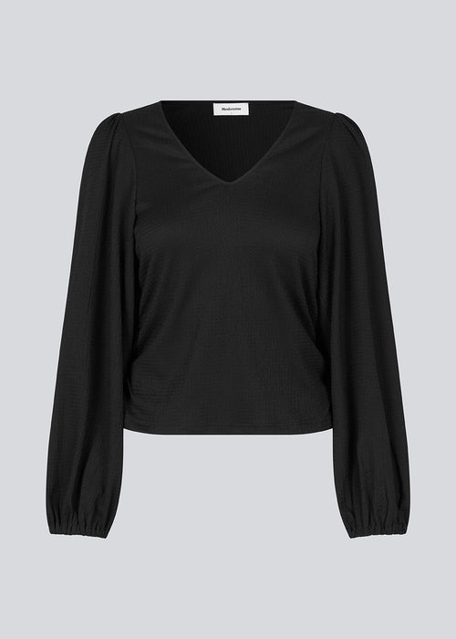 HarlandMD top in black has a regular fit in a woven quality with a v-shaped neckline in front, and long balloon sleeves with elasticated cuff. The model is 175 cm and wears a size S/36.