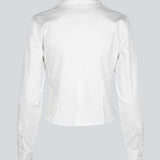 Form-fitting shirt in white in a woven cotton blend with collar, buttons in front, and long sleeves with cuff. HarrisonMD shirt has darts and a cutline below the chest for a corset-inspired look. The model is 175 cm and wears a size S/36.