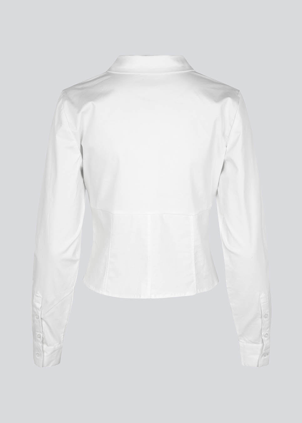 Form-fitting shirt in white in a woven cotton blend with collar, buttons in front, and long sleeves with cuff. HarrisonMD shirt has darts and a cutline below the chest for a corset-inspired look. The model is 175 cm and wears a size S/36.