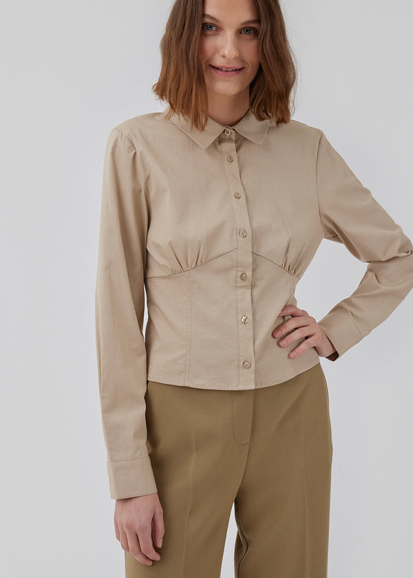 Form-fitting shirt in a woven cotton blend with collar, buttons in front, and long sleeves with cuff. HarrisonMD shirt has darts and a cutline below the chest for a corset inspired look. The model is 175 cm and wears a size S/36.