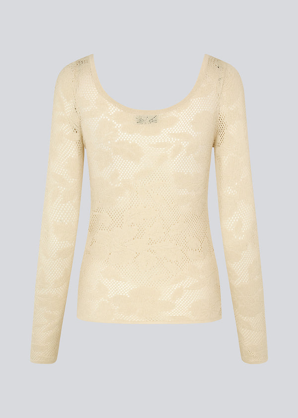 Tight-fitting top in beige in a stretchy lace material, that is slightly see-through. HawkinsMD top has long sleeves, and a deep neckline in front and back. 