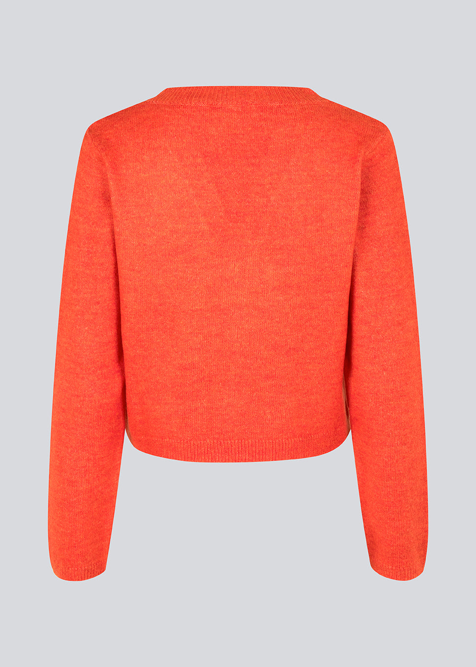 Cropped cardigan in bright red in a soft material. HeatMD cardigan has a v-neckline and button closure in front with ruching. The sleeves are long. 