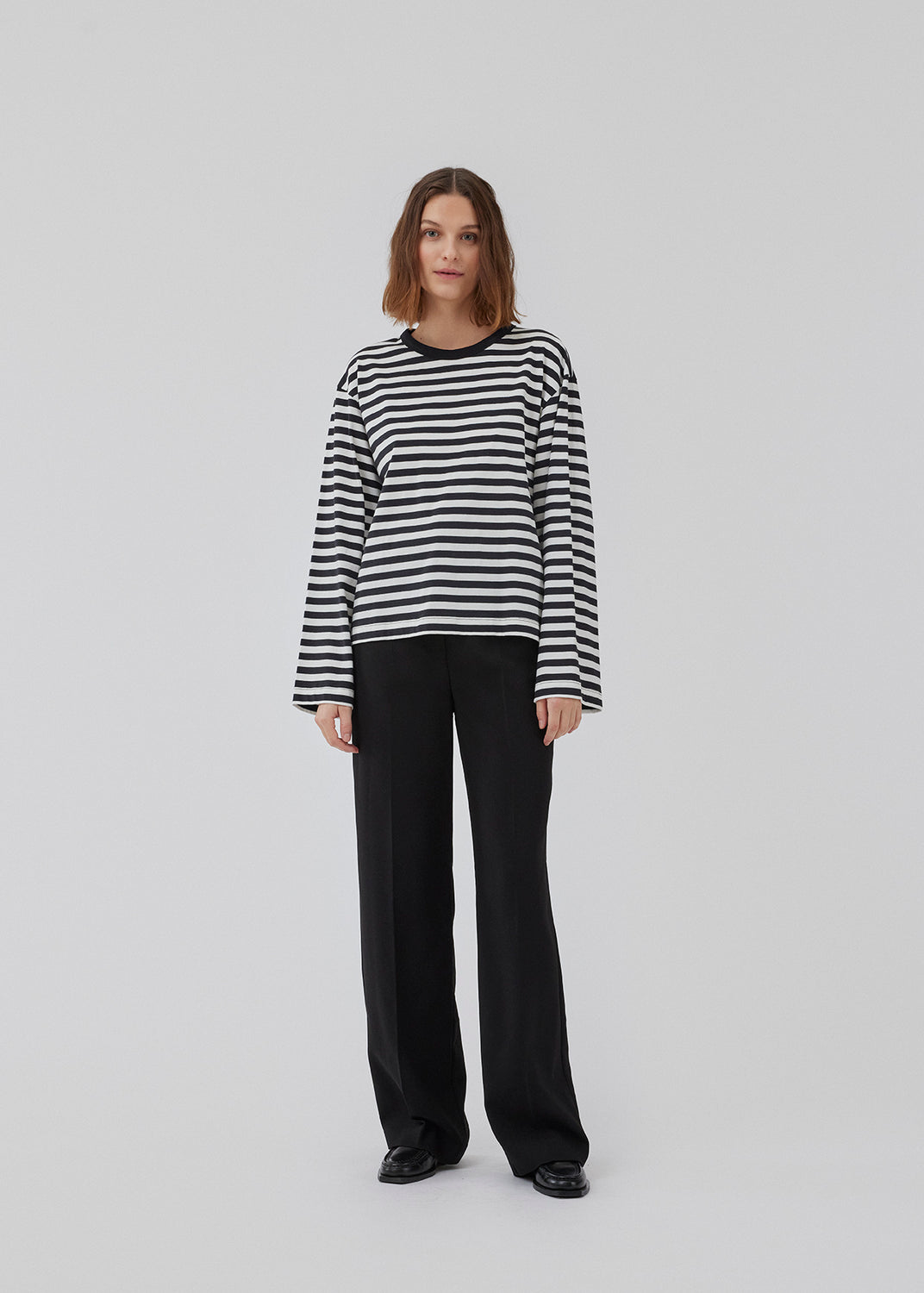 Longsleeved t-shirt in white made from cotton jersey with black stripes. HellenMD LS stripe t-shirt has a relaxed silhouette with wide sleeves and a round neck. The model is 175 cm and wears a size S/36.