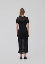 Midi dress in black in a patterned, transparent material. HendrickMD dress has a round neck and short sleeves. Slip dress with thin straps is included. The model is 175 cm and wears a size S/36.