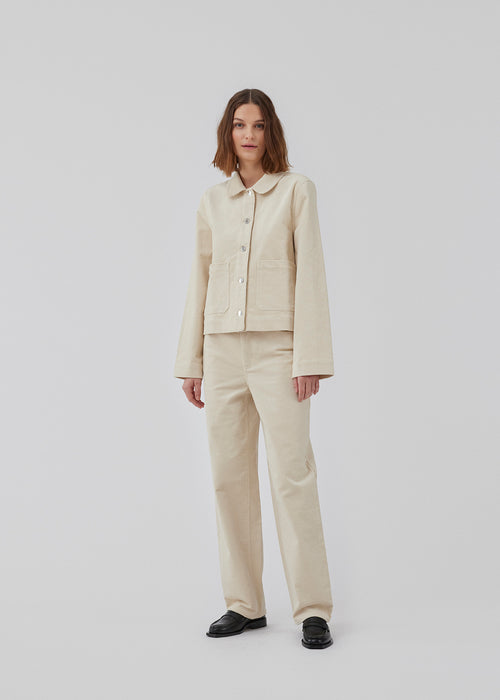 Cotton twill jacket with a straight fit, shirt collar, button closure in front, and long straight sleeves. Two large patch pockets in front. The model is 175 cm and wears a size S/36.