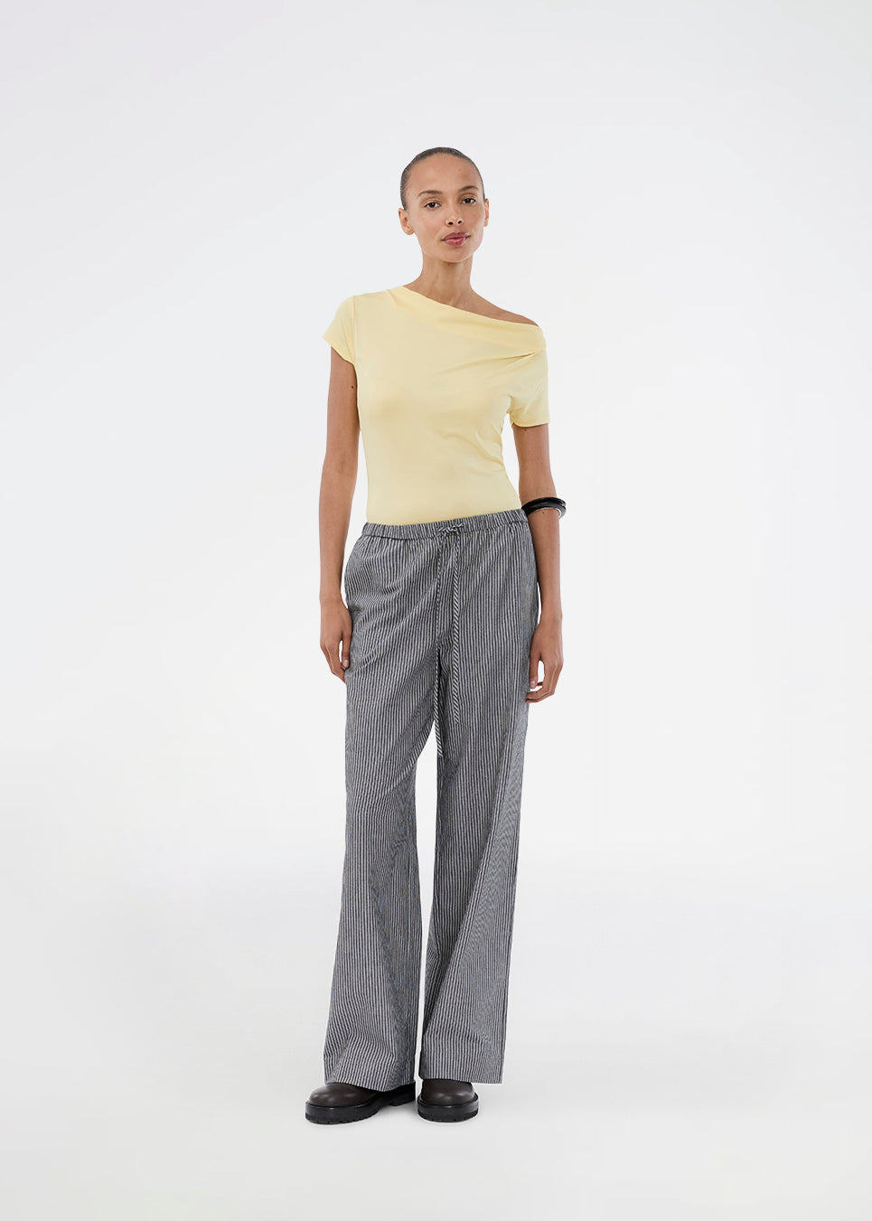 Fitted yellow T-shirt with draping. The Himamd Drapy T-shirt is made from 95% recycled polyester and features an elastic fit. The sophisticated draping adds a feminine and modern twist, perfect for both everyday and evening looks.&nbsp;
