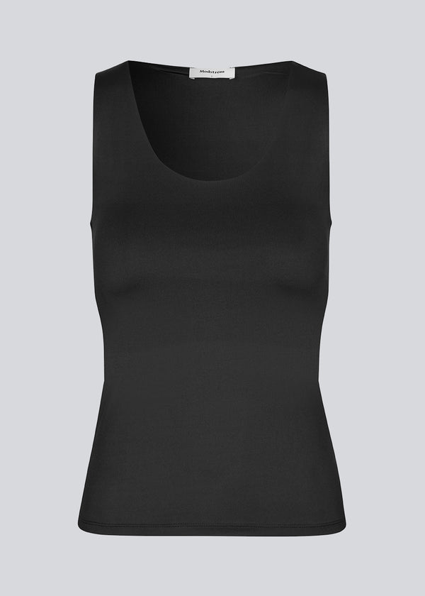 Black top with wide straps and stretch in recycled quality. HimaMD top has tight-fitted silhouette with chest reinforcement. The model is 175 cm and wears a size S/36.