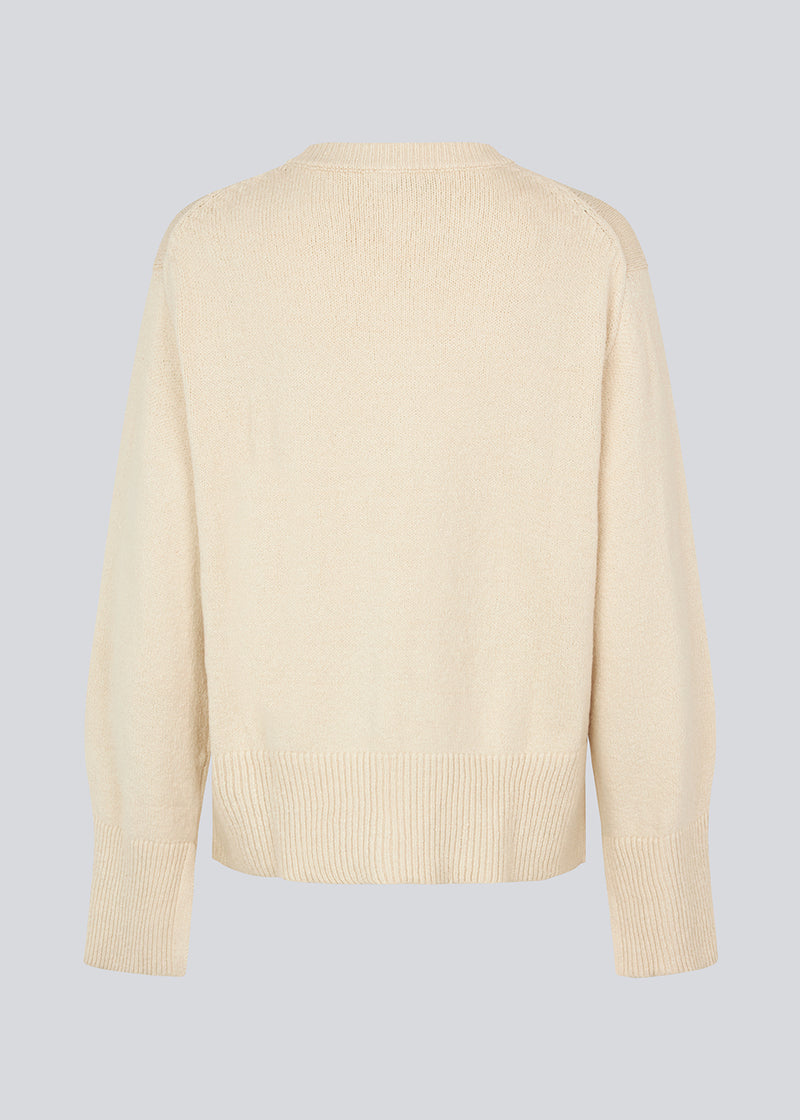 Knit jumper in beige in a cotton blend. HimmaMD cardigan has a relaxed silhouette with a round neck, dropped shoulders, and slits at cuffs. Wide rib trimmings at the neck, cuffs and hem. 