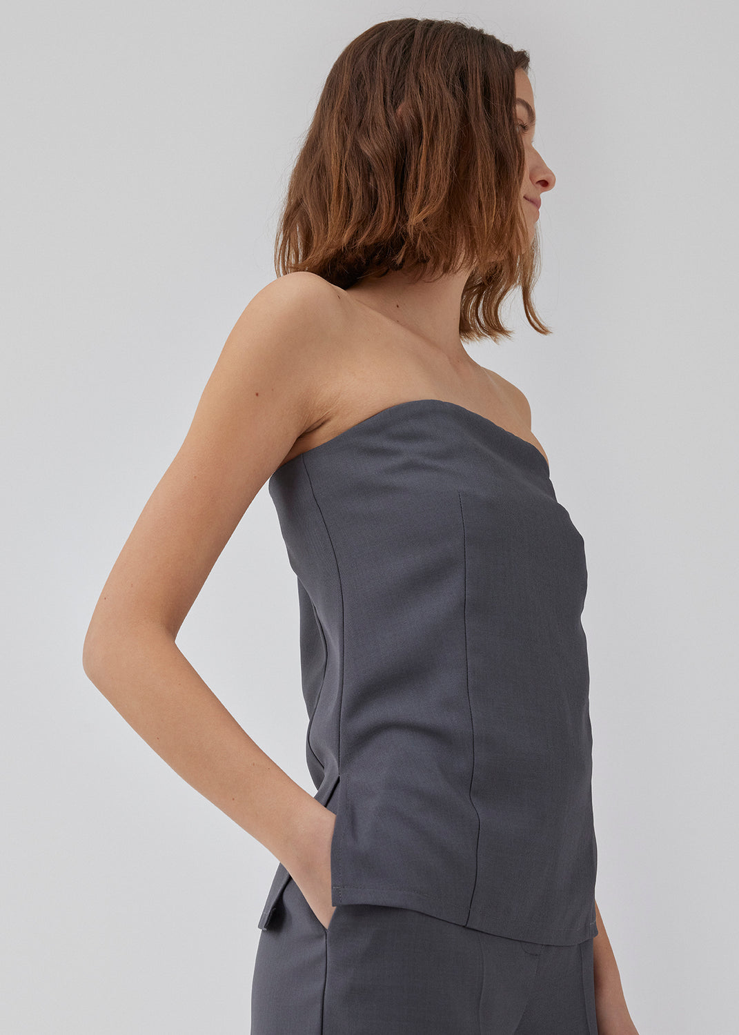 Fitted bandeau top with hidden silicone band at the top for hold. HinaMD top has a hidden zipper at one side. The model is 175 cm and wears a size S/36.