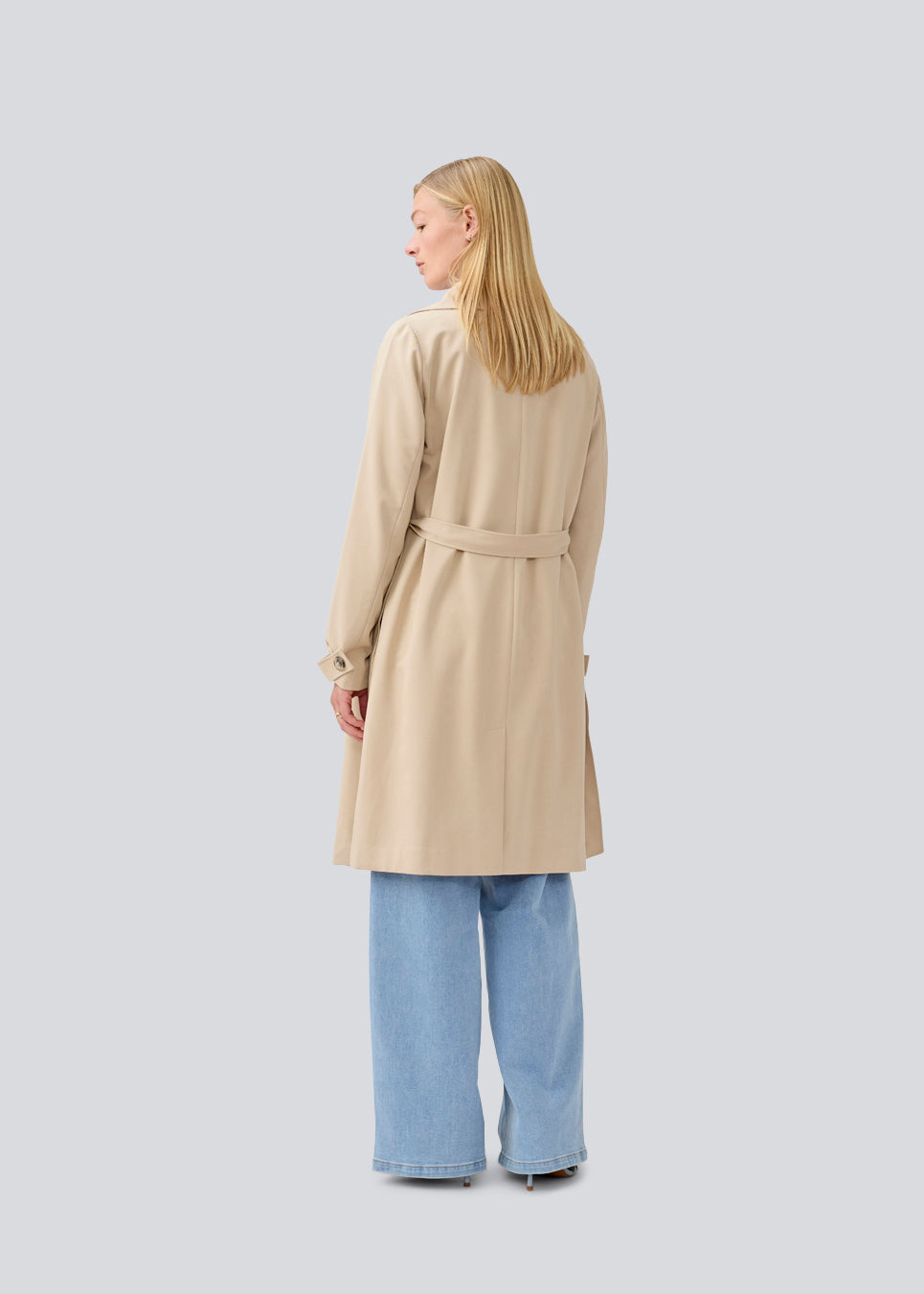 Beautiful beige jacket with a classic look and wide revers, belted waist and button closure. Hiro jacket is one of our most popular styles and the perfect transition jacket. This jacket has a spacious fit. We recommend sizing down. The model is 174 cm and wears a size S/36