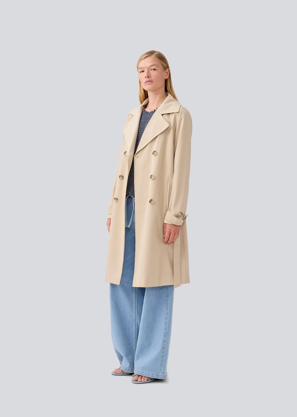 Beautiful beige jacket with a classic look and wide revers, belted waist and button closure. Hiro jacket is one of our most popular styles and the perfect transition jacket. This jacket has a spacious fit. We recommend sizing down. The model is 174 cm and wears a size S/36