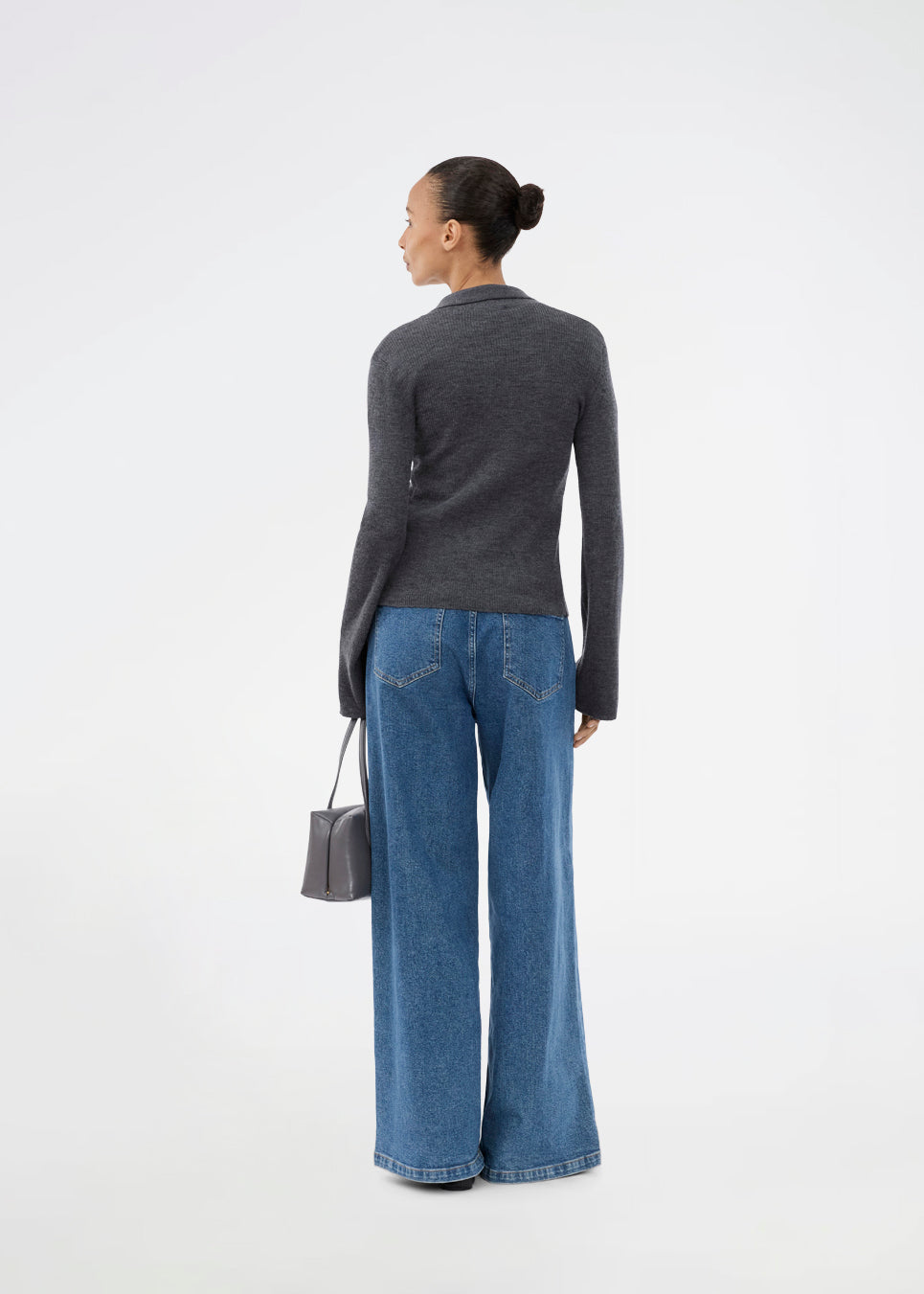 Dark grey fitted cardigan made from a soft, rib-knitted wool. HirokiMD cardigan has a collar, buttons in front, and long sleeves with slit and buttons. The model is 175 cm and wears a size S/36.