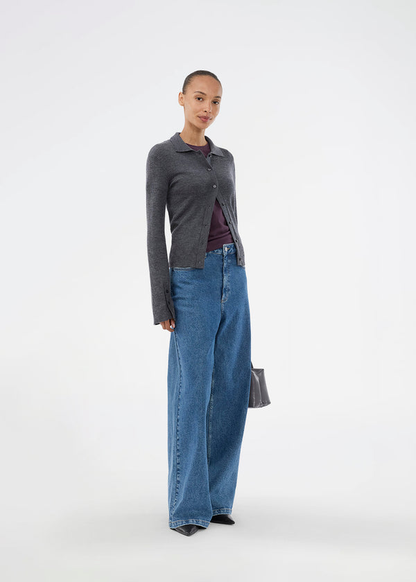 Dark grey fitted cardigan made from a soft, rib-knitted wool. HirokiMD cardigan has a collar, buttons in front, and long sleeves with slit and buttons. The model is 175 cm and wears a size S/36.