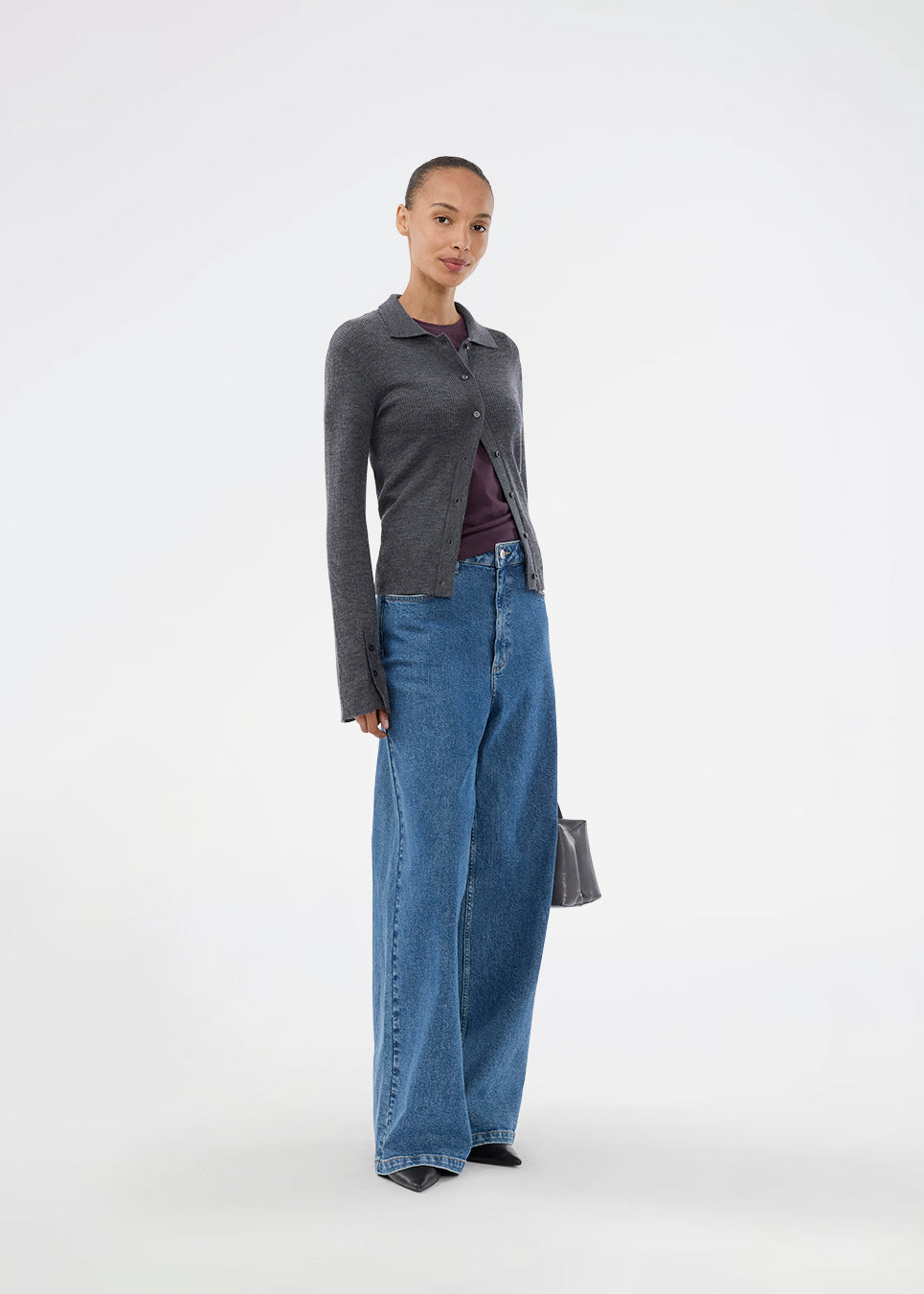 Dark grey fitted cardigan made from a soft, rib-knitted wool. HirokiMD cardigan has a collar, buttons in front, and long sleeves with slit and buttons. The model is 175 cm and wears a size S/36.