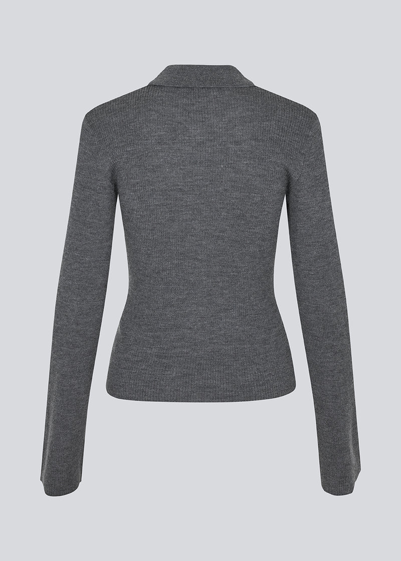 Dark grey fitted cardigan made from a soft, rib-knitted wool. HirokiMD cardigan has a collar, buttons in front, and long sleeves with slit and buttons. The model is 175 cm and wears a size S/36.