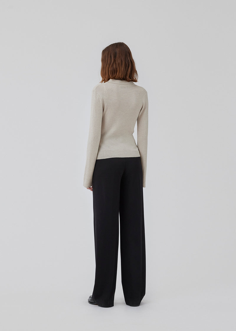 Fitted cardigan in beige made from a soft, rib-knitted wool. HirokiMD cardigan has a collar, buttons in front, and long sleeves with slit and buttons. The model is 175 cm and wears a size S/36.
