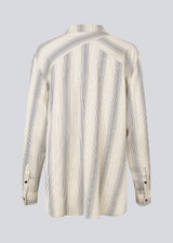 Oversize shirt with collar and button closure in front. HissaMD print shirt has wide sleeves with cuff, and a detailed yoke at the back. 