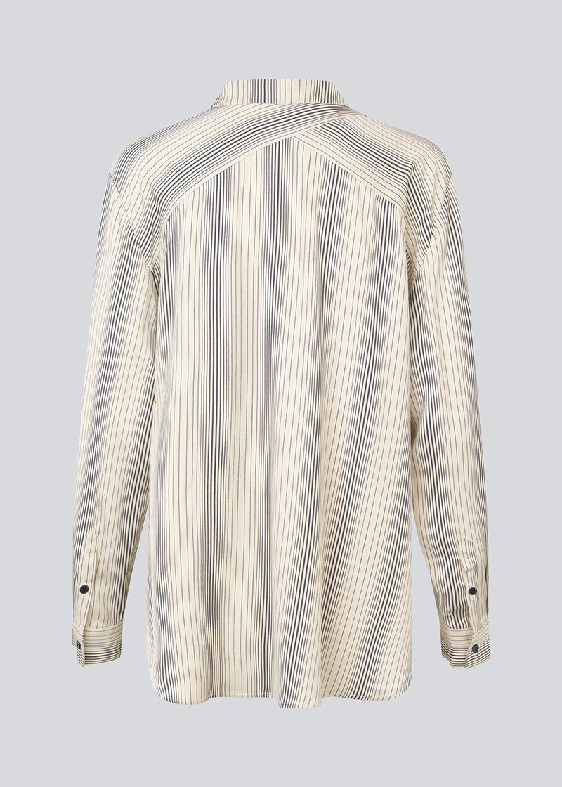 Oversize shirt with collar and button closure in front. HissaMD print shirt has wide sleeves with cuff, and a detailed yoke at the back. 