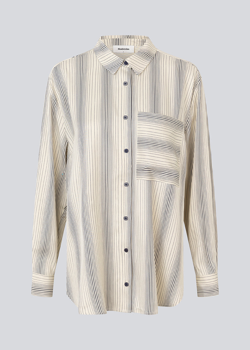 Oversize shirt with collar and button closure in front. HissaMD print shirt has wide sleeves with cuff, and a detailed yoke at the back. 