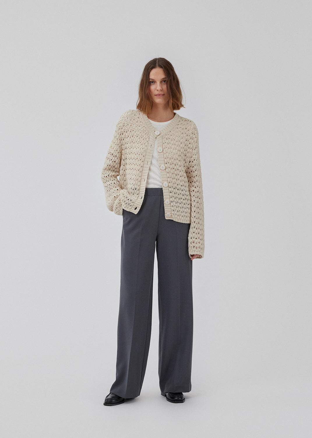 Cardigan in crochet look in organic cotton. HobbsMD solid cardigan has a casual look with a round neck with button closure in front, and long sleeves. The model is 175 cm and wears a size S/36.