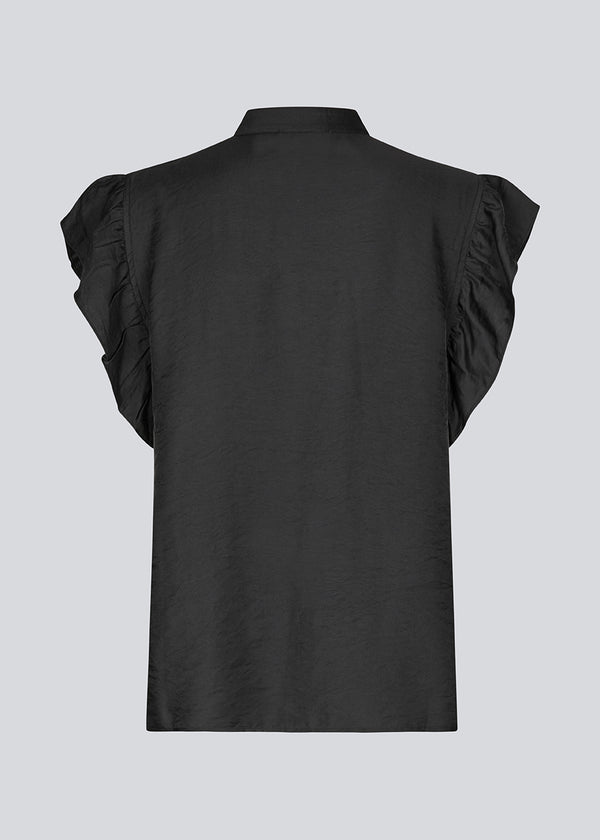 HolidayMD top in black is designed with a standing collar and button closure in front. The top has a frilly detail along the placket and at the armholes.&nbsp;