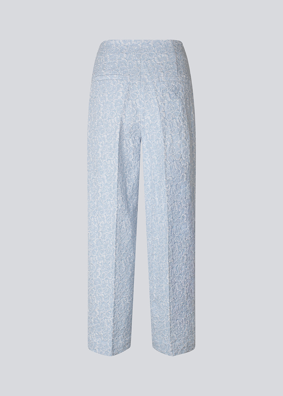 Pants in a light blue color with straight legs in a structured material. HollisMD pants have a medium waist with a hidden zipper at one side, and two welt pockets on the back.