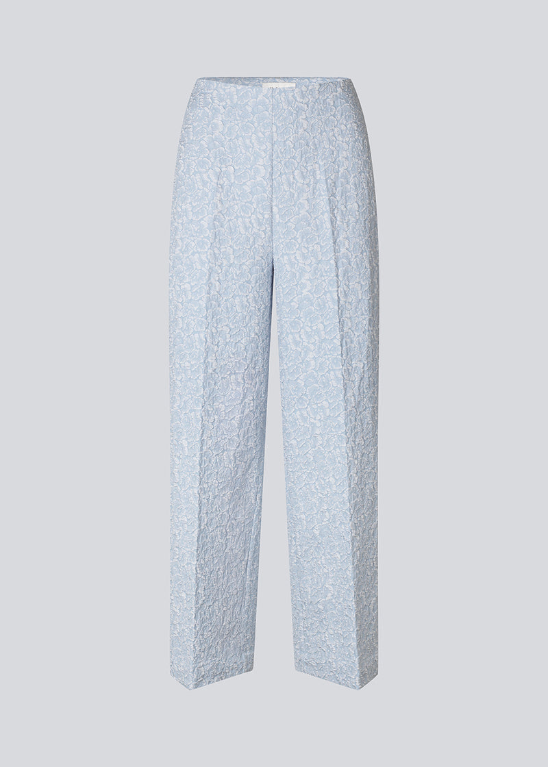 Pants in a light blue color with straight legs in a structured material. HollisMD pants have a medium waist with a hidden zipper at one side, and two welt pockets on the back.